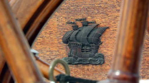Das Relief eines Segelschiffs auf der Seite eines Backsteinhauses